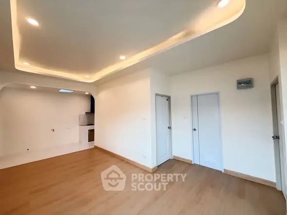 Spacious modern living room with elegant ceiling lights and wooden flooring