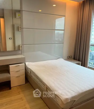 Modern bedroom with sleek design and large window offering city view.