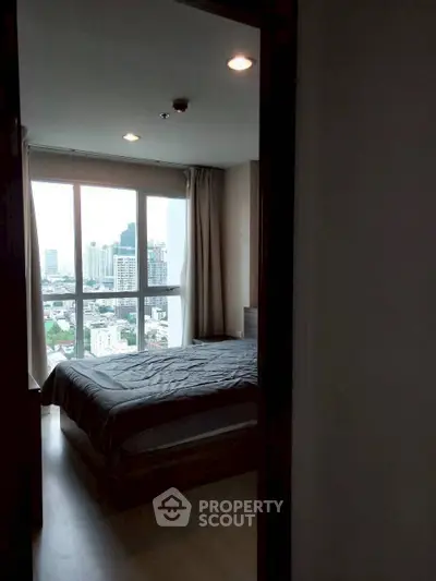 Cozy bedroom with city view and large windows in modern apartment
