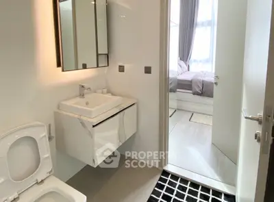 Modern bathroom with sleek fixtures and view into a stylish bedroom