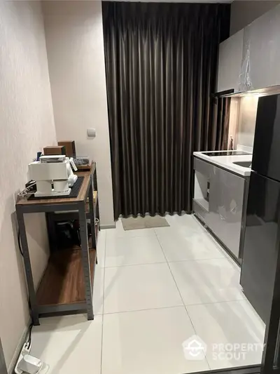 Modern compact kitchen with sleek cabinetry and stylish curtains