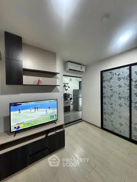 Modern living room with TV, air conditioning, and stylish shelving.