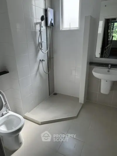 Modern bathroom with sleek shower and white tiles, perfect for a contemporary home.