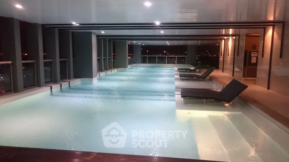 Luxurious indoor pool with city view in modern high-rise building