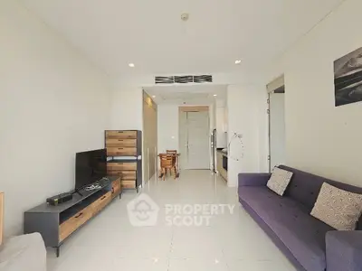 Modern living room with sleek furniture and open layout, featuring a cozy sofa and entertainment center.