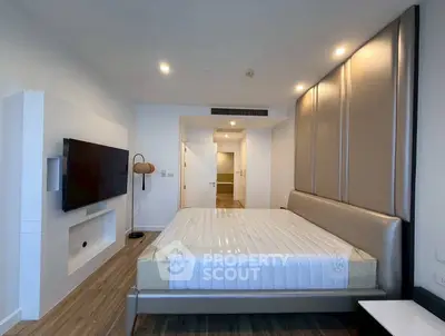 Modern bedroom with sleek design and large wall-mounted TV