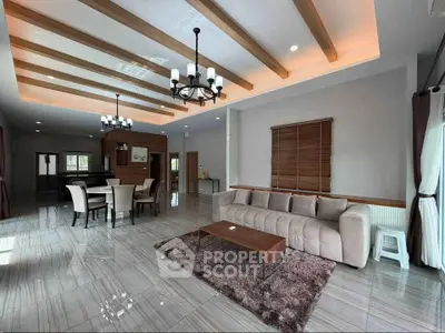 Spacious modern living room with elegant ceiling beams and cozy seating area.