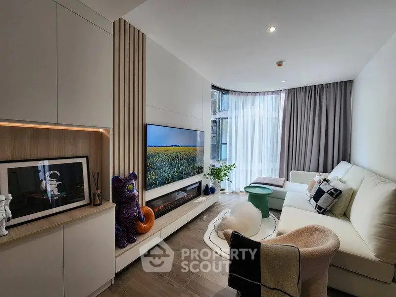 Modern living room with sleek design, large TV, and cozy seating area.