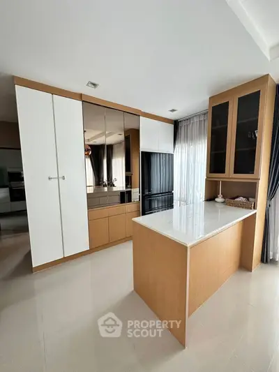 Modern kitchen with sleek cabinetry and island in a bright, open space.