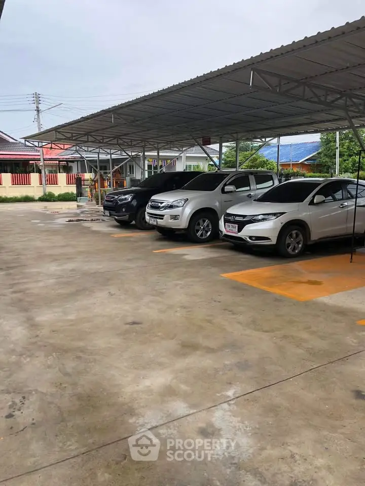 Spacious covered parking area with multiple vehicles in a residential complex.