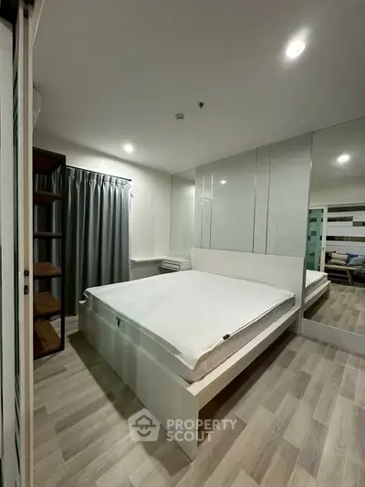 Modern bedroom with sleek design and mirrored closet doors in a stylish apartment.
