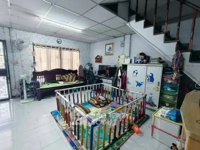 Spacious living room with playpen, cozy seating, and ample natural light, perfect for family living.