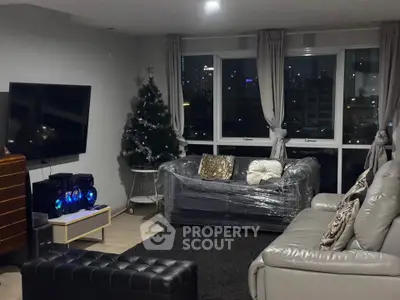 Modern living room with city view, stylish furniture, and Christmas decor.