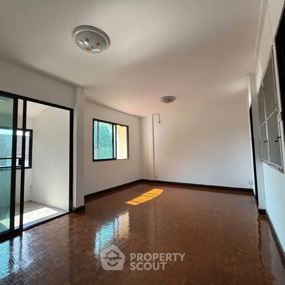 Spacious living room with parquet flooring and natural light in modern apartment