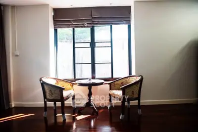 Cozy seating area with elegant chairs and table by a sunlit window