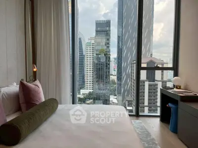 Luxurious bedroom with stunning city view and modern decor in high-rise apartment.