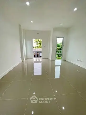 Spacious empty room with glossy tiled floor and natural light
