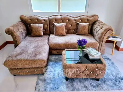 Luxurious living room with plush brown sofa and elegant glass-top coffee table on a soft rug.