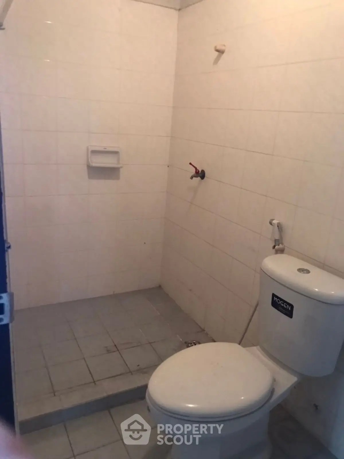 Compact bathroom with tiled walls and toilet, ideal for small spaces.