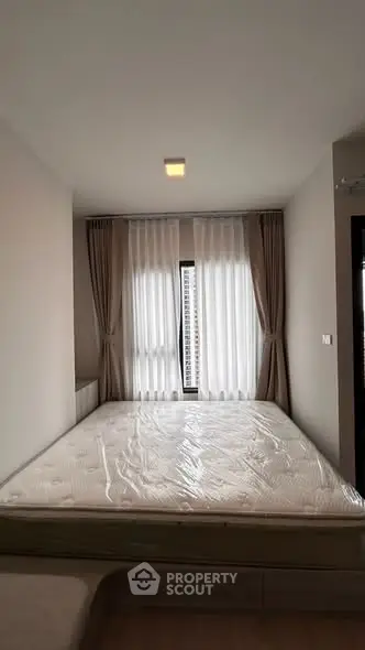 Modern bedroom with large window and elegant curtains in a stylish apartment.
