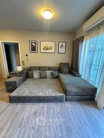 Spacious living room with modern gray sectional sofa and stylish decor, perfect for relaxation and entertainment.