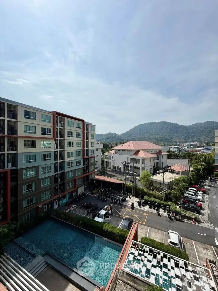 Stunning view of modern apartment complex with pool and mountain backdrop, perfect for urban living.