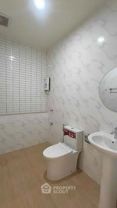 Modern bathroom with sleek fixtures and marble-patterned tiles