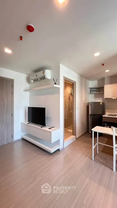 Modern apartment interior with open layout, featuring a sleek kitchen and cozy living area.