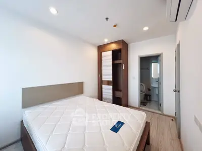 Modern bedroom with wooden wardrobe and ensuite bathroom in a stylish apartment.