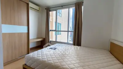 Modern bedroom with large window and built-in wardrobe in urban apartment