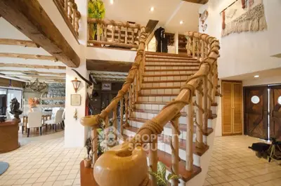Stunning rustic interior with wooden staircase and open living area, perfect for cozy gatherings.