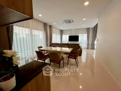 Spacious modern living room with elegant dining area and large windows.