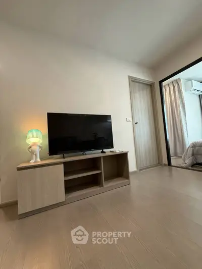 Modern living room with sleek TV stand and cozy bedroom view