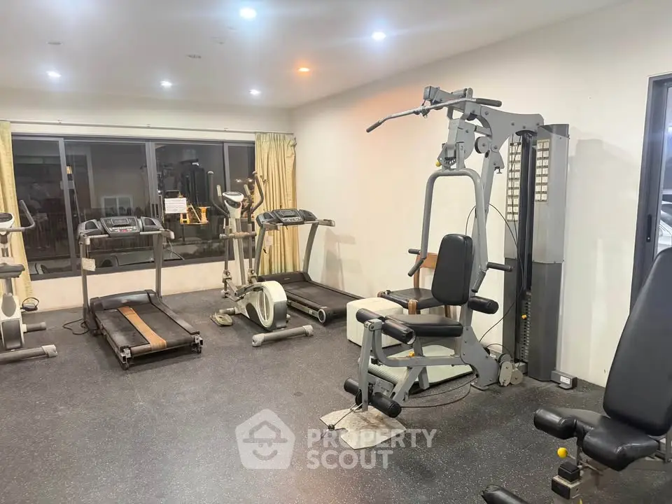 Spacious gym with modern fitness equipment in a residential building.