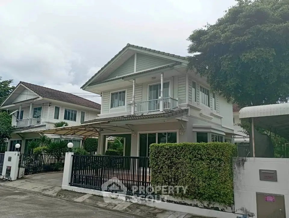 Charming two-story house with lush greenery and spacious driveway in a serene neighborhood.