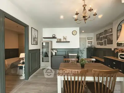 Charming living room with elegant chandelier and cozy dining area, featuring tasteful decor and warm lighting.
