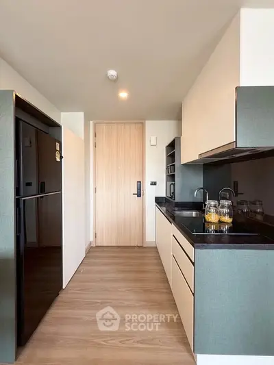 Modern kitchen with sleek cabinetry and black countertops in a stylish apartment.