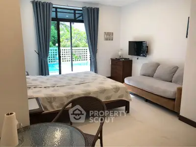 Spacious bedroom with pool view, cozy seating area, and modern decor