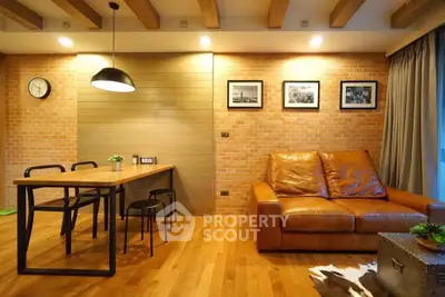 Stylish living room with leather sofa, wooden floor, and modern dining area in a cozy apartment.