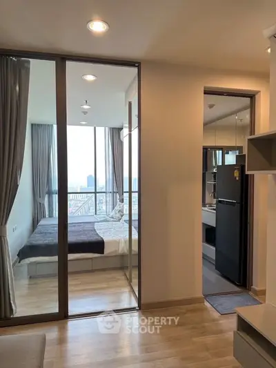 Modern apartment with glass-walled bedroom and city view from balcony.