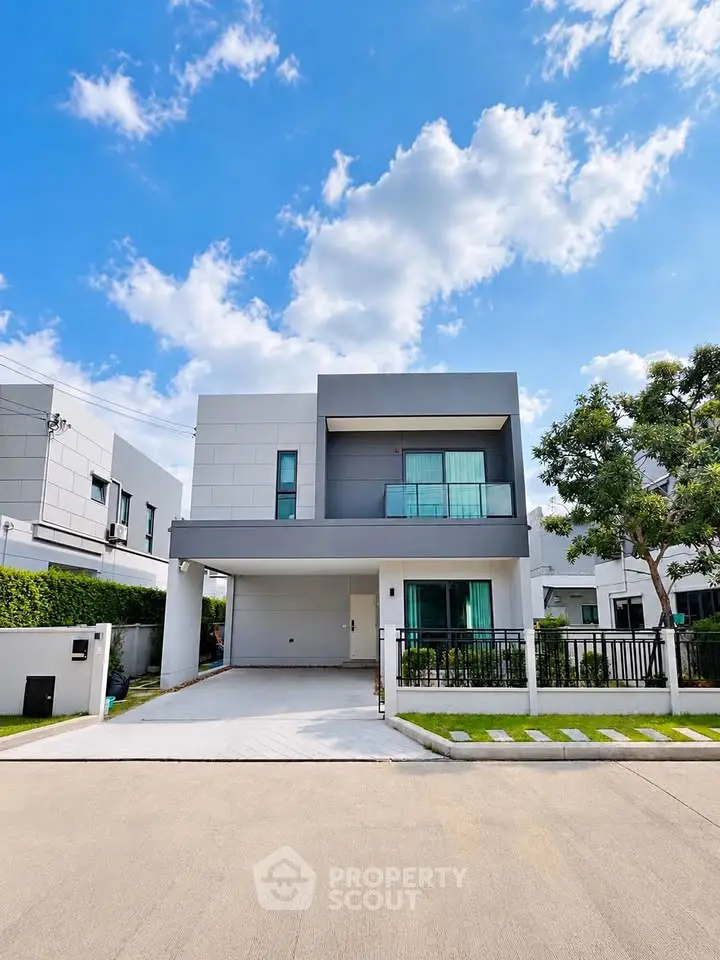 Modern two-story house with sleek design and spacious driveway in a serene neighborhood.