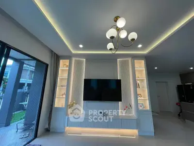 Modern living room with elegant lighting and built-in TV unit, showcasing contemporary design.