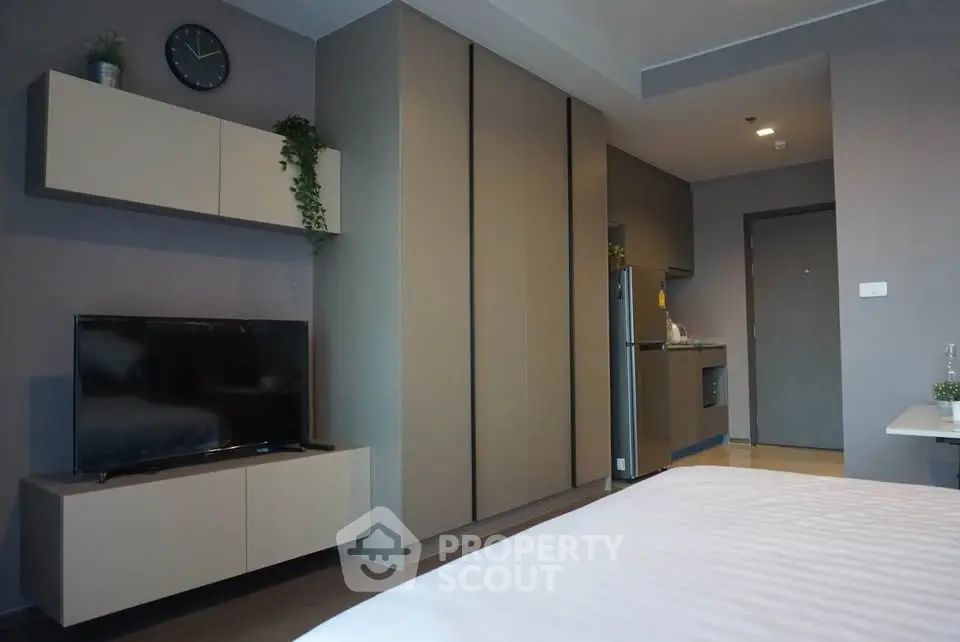 Modern studio apartment with sleek design and integrated kitchen area.