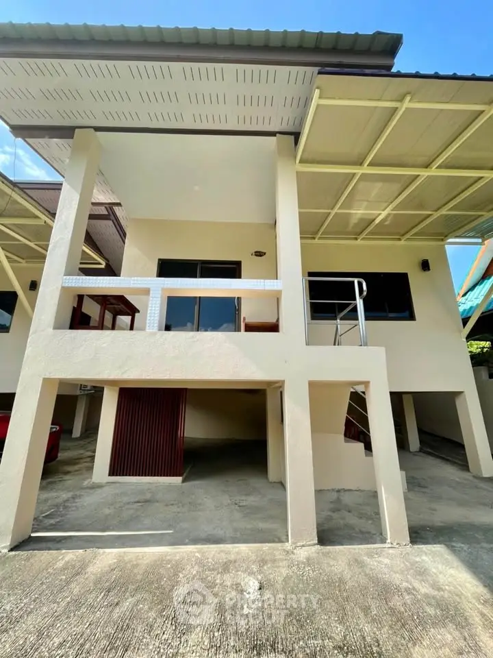 Modern two-story house with covered parking and balcony, showcasing contemporary architecture and spacious design.