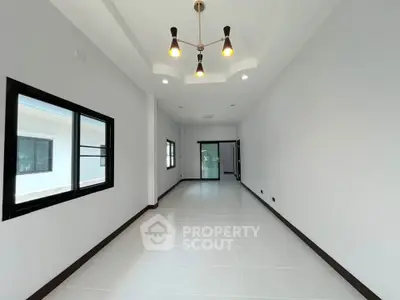 Spacious modern living room with elegant lighting and large windows in a contemporary home.