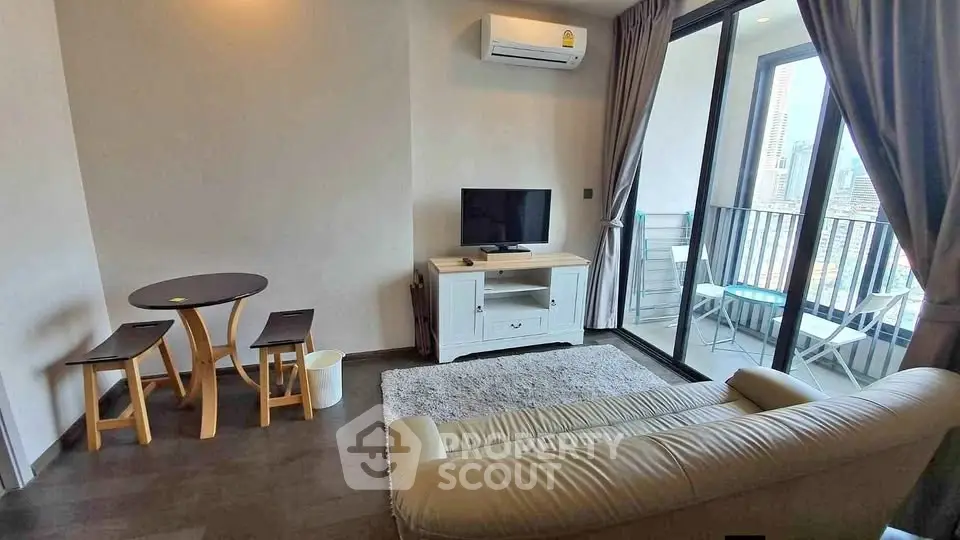 Modern living room with balcony view, featuring cozy seating and stylish decor.