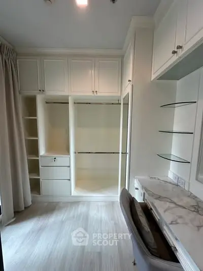 Spacious walk-in closet with elegant marble desk and ample storage space.