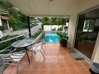 Charming balcony with pool view, perfect for relaxation and outdoor dining.