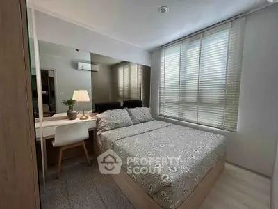 Cozy bedroom with modern decor and ample natural light from large windows.