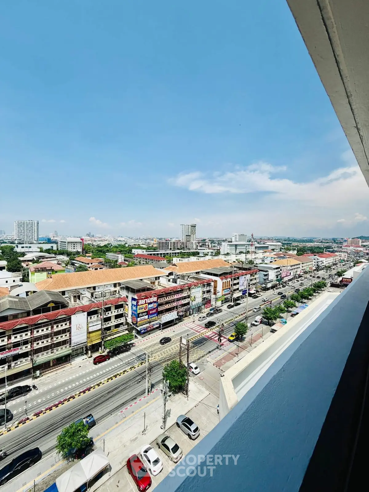 Stunning cityscape view from a high-rise balcony showcasing vibrant urban life and architecture.